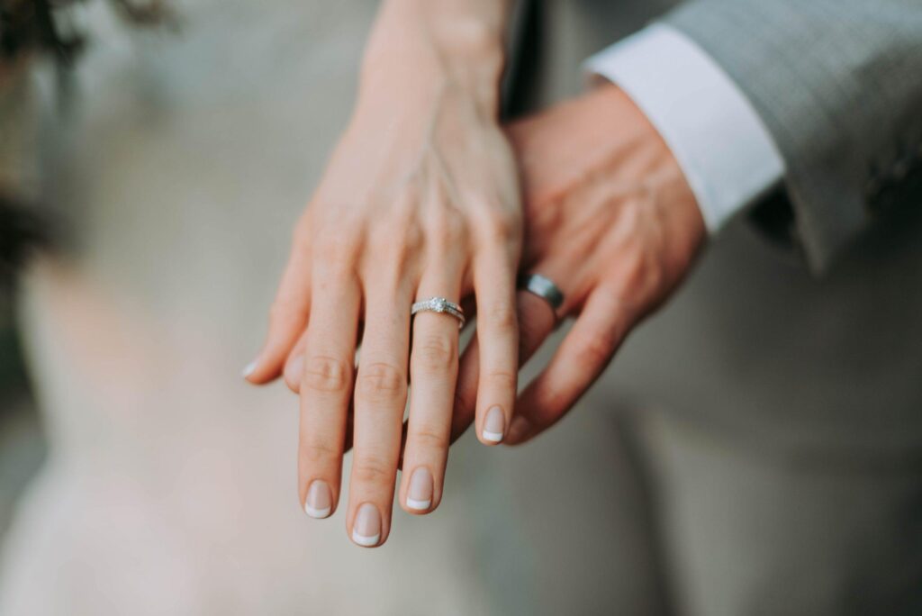 Hands overlapping wearing wedding bands
