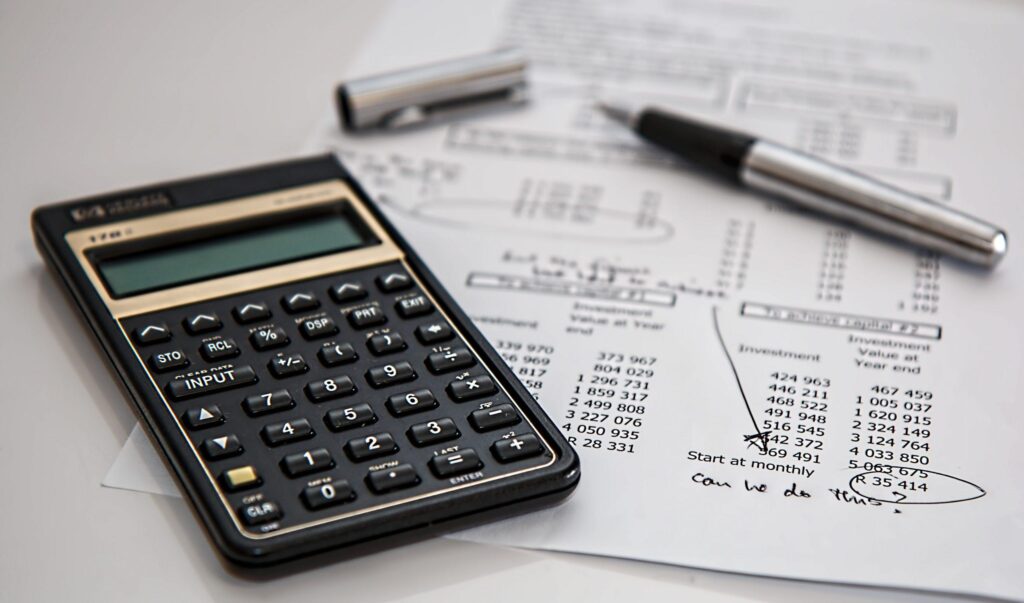 Calculator and pen on top of account working out budget