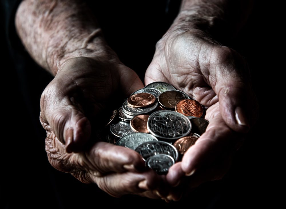 Hands holding a pile of coins